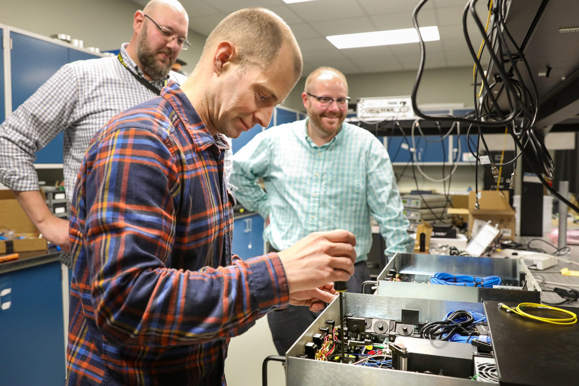 ORNL quantum researchers, from left, Brian Williams, Phil Evans and Nick Peters work on their QKD system. Credit: Genevieve Martin/Oak Ridge National Laboratory, U.S. Dept. of Energy